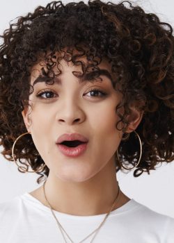 Oh wow. Entertained impressed silly attractive curly hairstyle mixed-race lesbian girl look surprised open mouth astonished smiling glad hear good amusing news, standing white background.